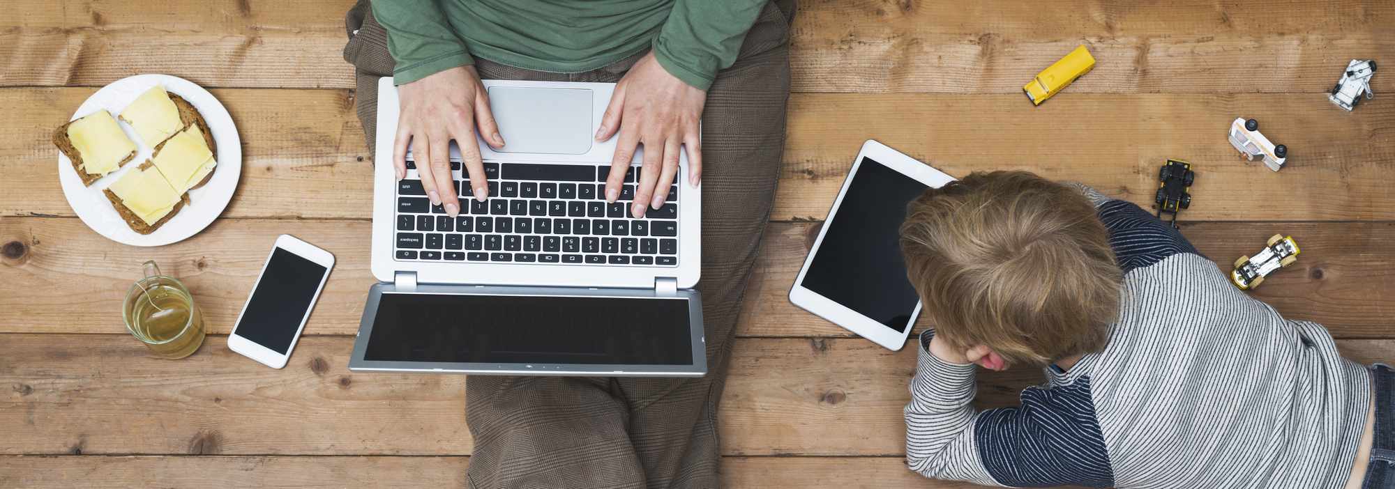 Overhead shot of a parent and child using different types of technology.