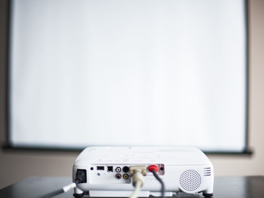 Projector and screen in a bare room