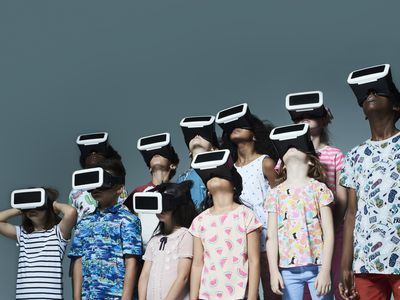 A group of children using VR headsets and looking skyward.