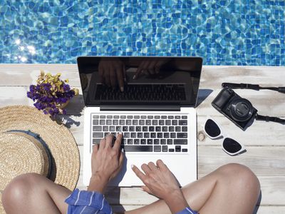 A pool landscape with a MacBook in front of it and a person's hands typing on the keyboard