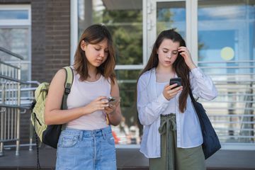 Two girls using smartphones.