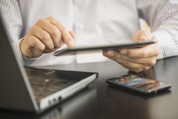 Man using tablet with multiple devices