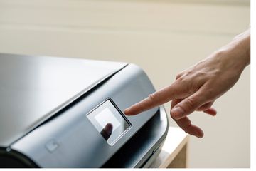 Person touching the screen on a wireless printer.